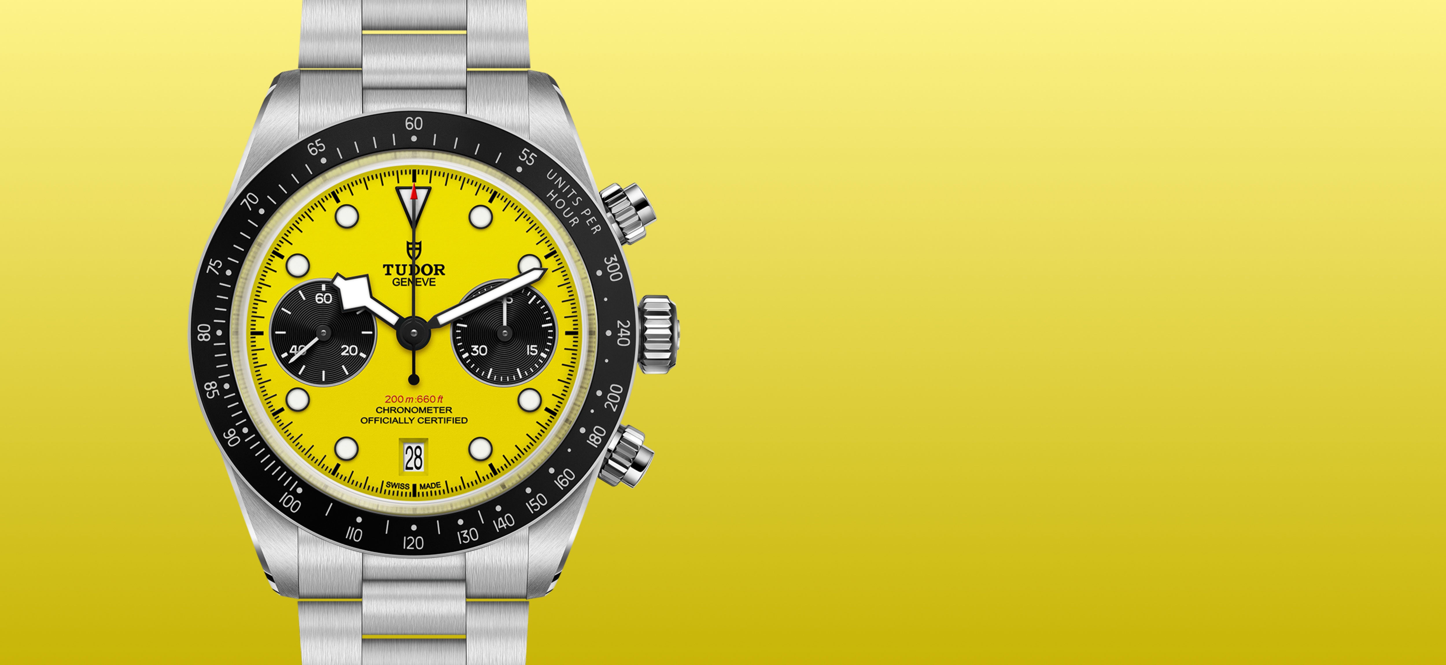 A Tudor Black Bay Chrono 39 with a yellow face and stainless steel case and bracelet set against a yellow background