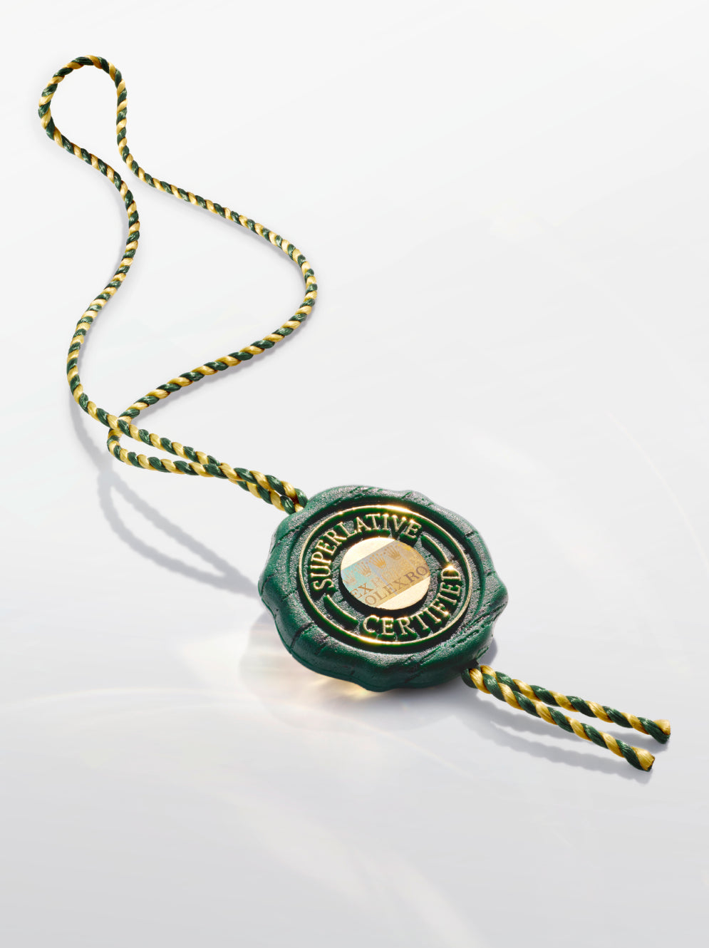 Green wax seal with gold accents on a white background. The words "Superlative Certified" are written around its perimeter. In the middle of the seal there is a holographic feature containing the word Rolex repeatedly.