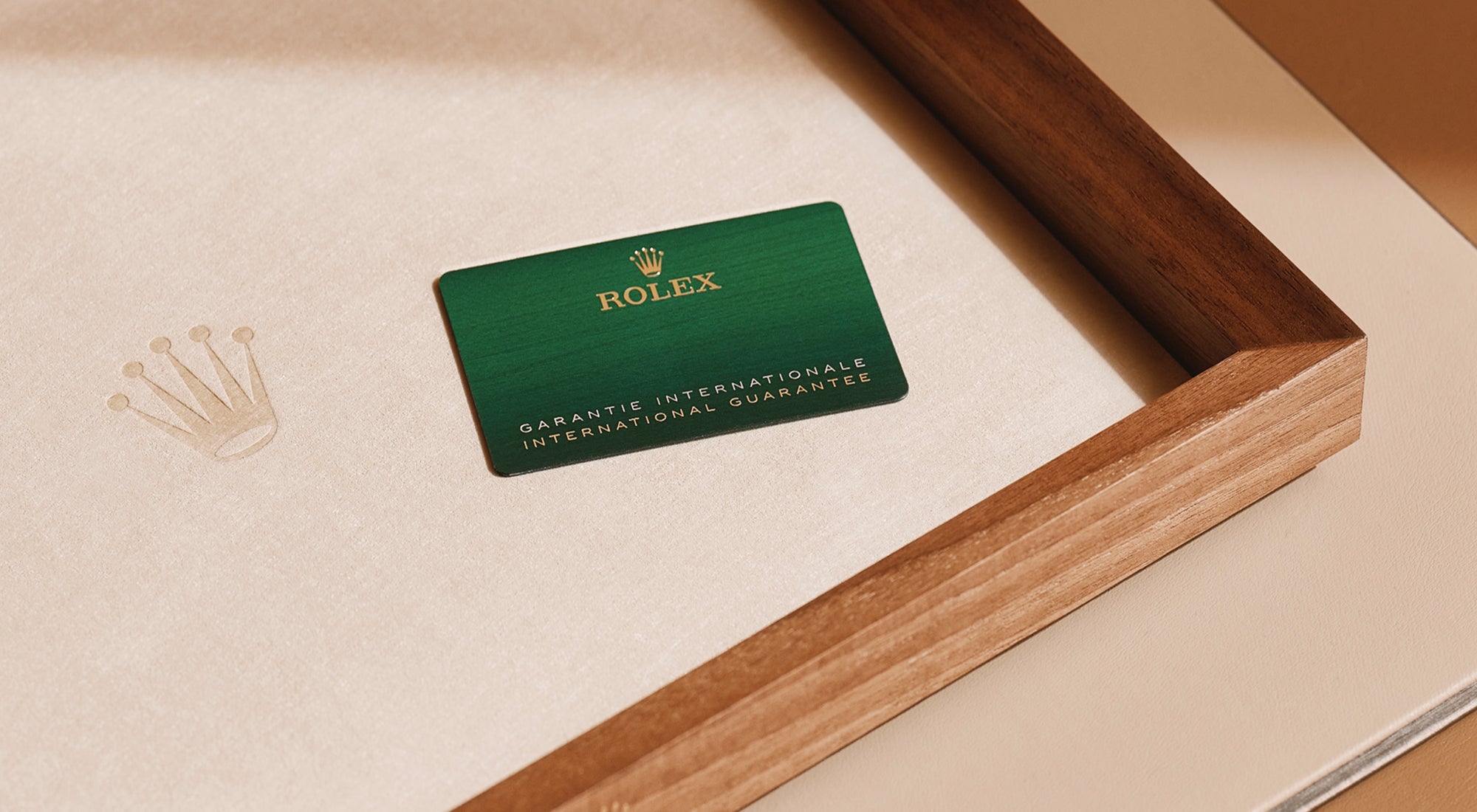 Rolex guarantee card on a luxurious wood-trimmed tray