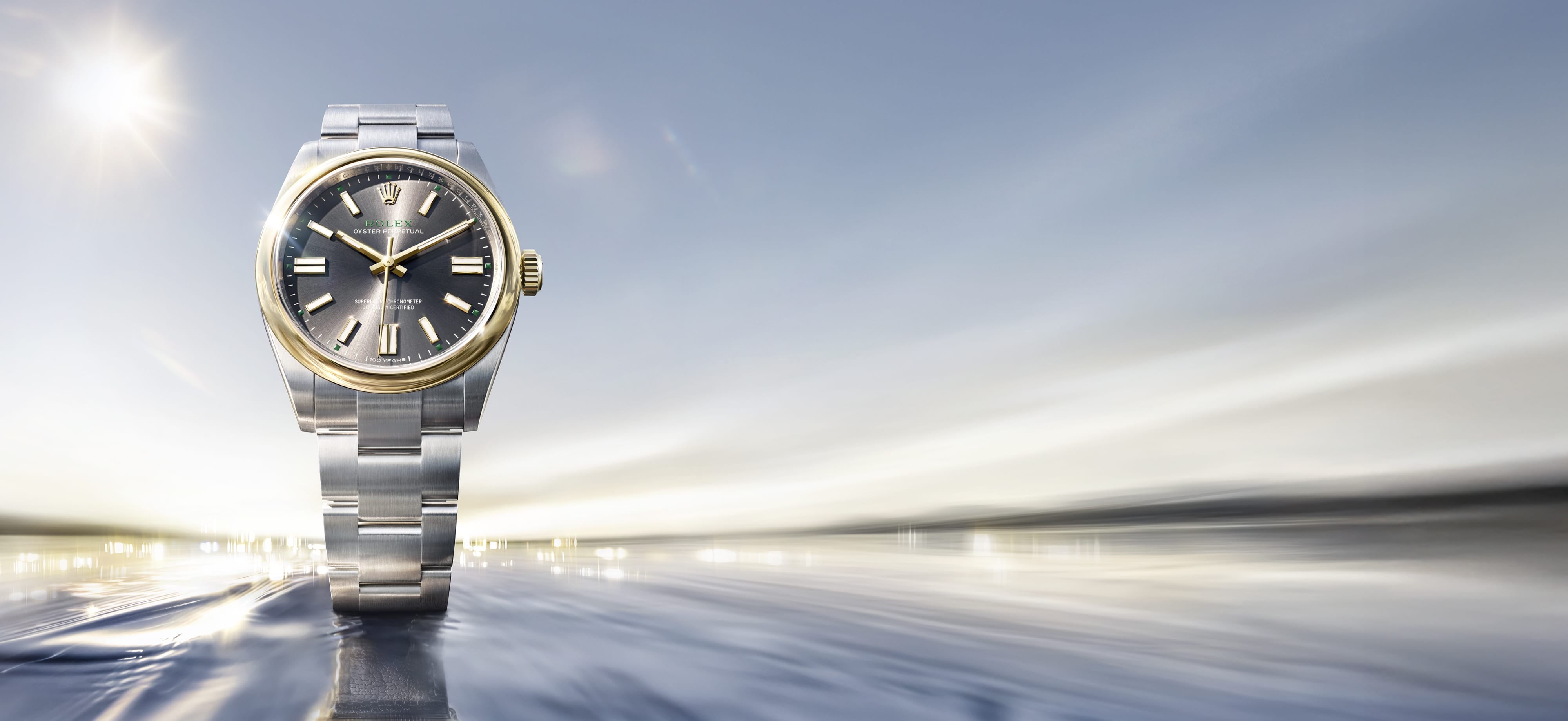 Rolex Oyster Perpetual 41 in Rolesor, a stunning combination of Oystersteel and solid 18 carat yellow gold, set elegantly on a beachfront. A commemorative timepiece marking the 100th anniversary of the invention of the Rolex Oyster waterproof case. 