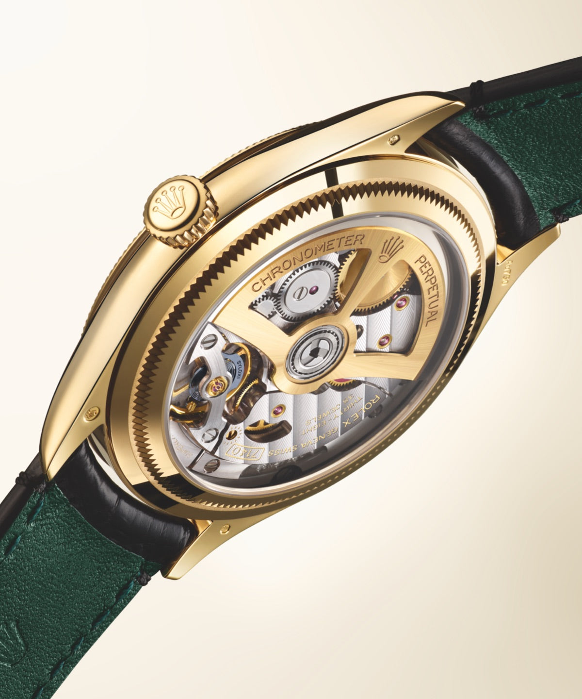 A Rolex 1908 in solid 19 carat yellow gold fitted to a black leather strap. The backside of the strap is lined with green. The timepiece is hovering in mid air against a creamy white background, displaying the intricate movement inside through a transparent sapphire crystal on the caseback.